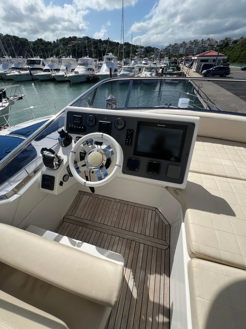 Slide: The Image of Flybridge helm of 2016 Azimut 54fly yacht, docked at marina with scenic background. - 6