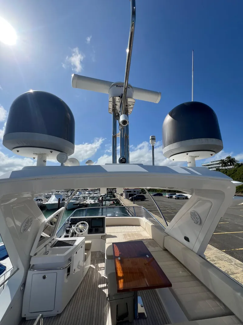 Slide: The Image of 2016 Azimut 54fly yacht flybridge with radar domes and seating area under clear blue sky. - 9