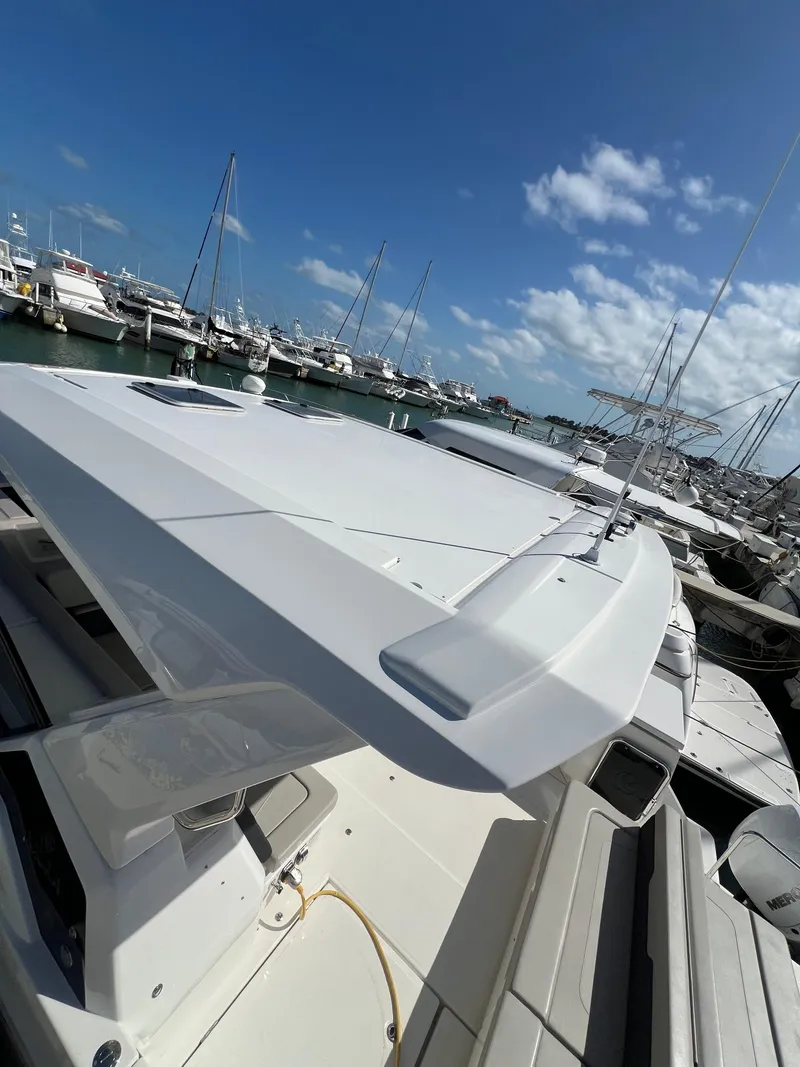 Slide: The Image of 2023 Aquila 36 Sport yacht docked at a marina under a clear blue sky. - 14