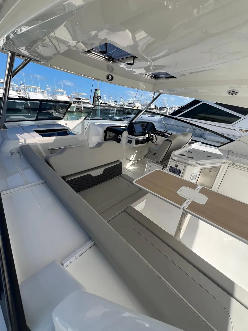Slide: The Image of 2023 Aquila 36 Sport yacht interior with modern seating and helm, docked at marina. - 15