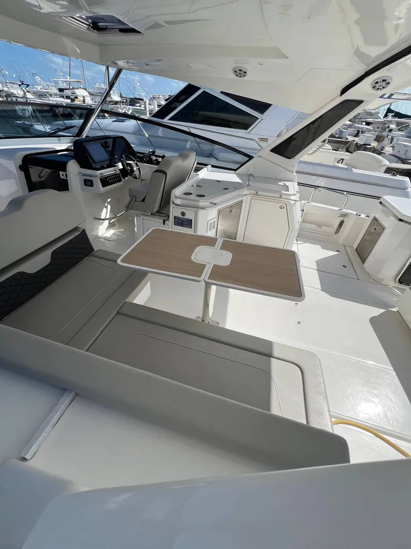 Slide: The Image of 2023 Aquila 36 Sport yacht interior with seating and helm, docked at marina. - 16