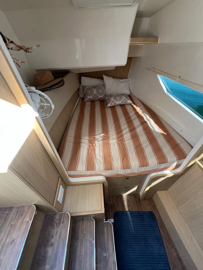 Slide: The Image of 2023 Aquila 36 Sport cabin interior with striped bedding and wooden accents. - 20