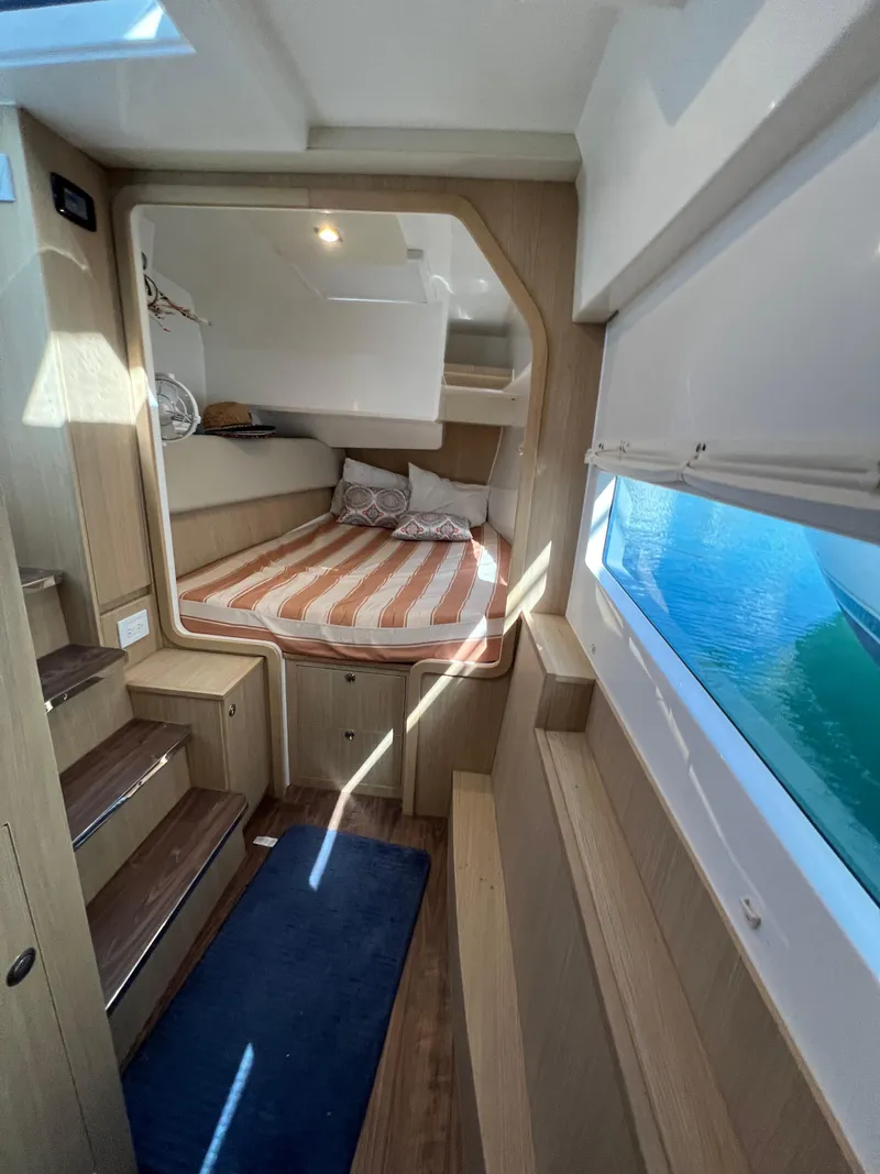 Slide: The Image of Interior cabin of 2023 Aquila 36 Sport yacht with striped bedding and wooden finishes. - 23