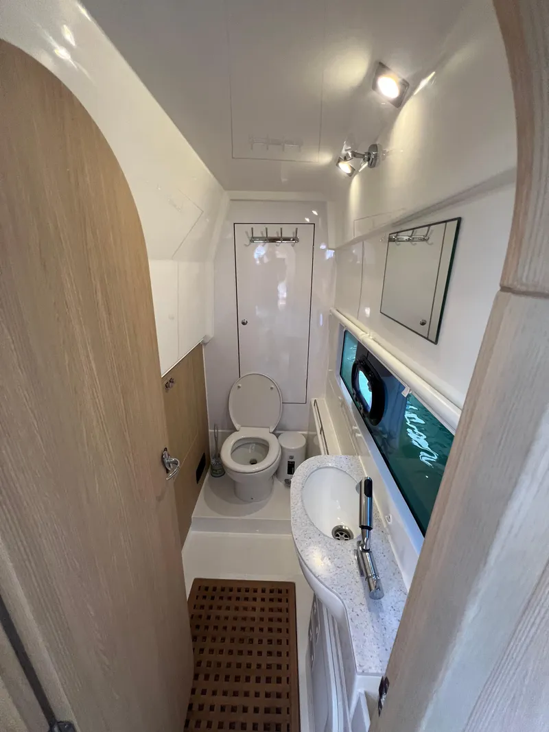 Slide: The Image of 2023 Aquila 36 Sport bathroom with toilet, sink, and mirror. - 26