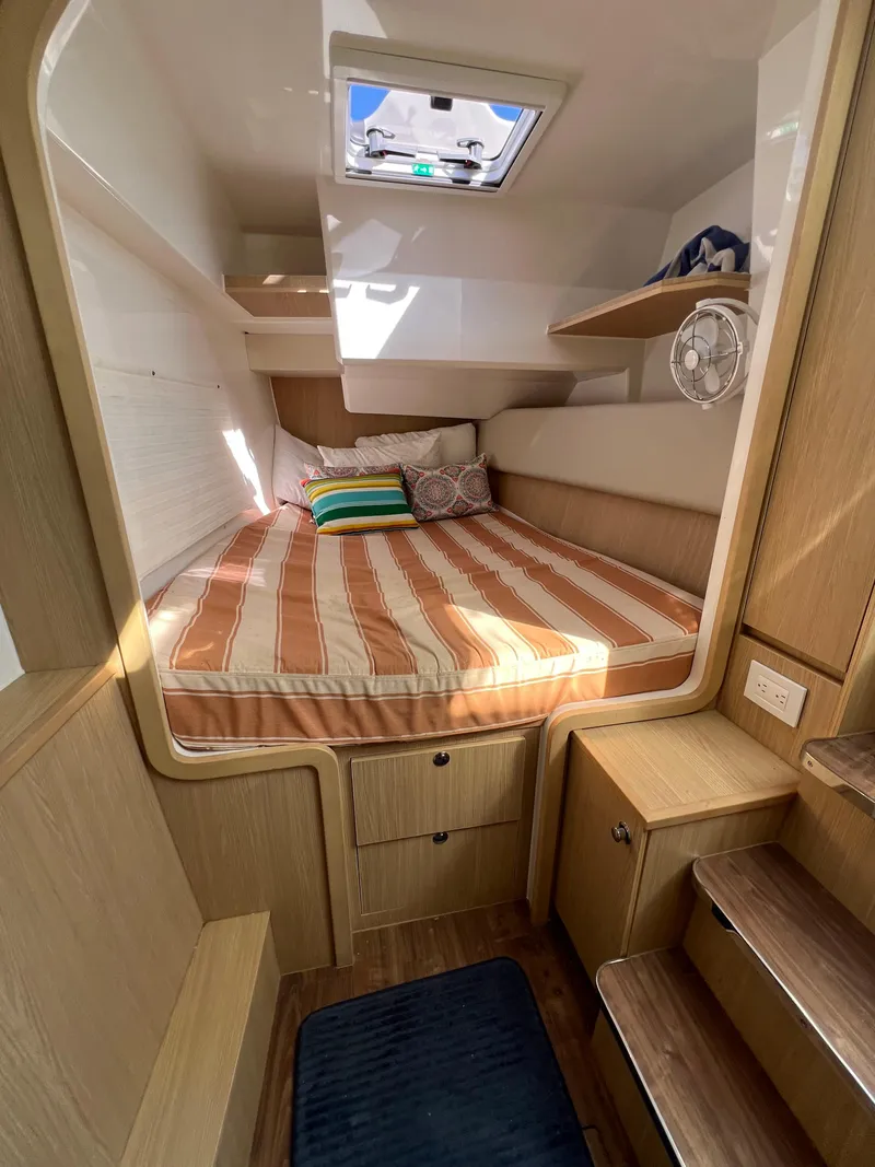 Slide: The Image of Cozy cabin interior of 2023 Aquila 36 Sport with striped bedding and wooden accents. - 27