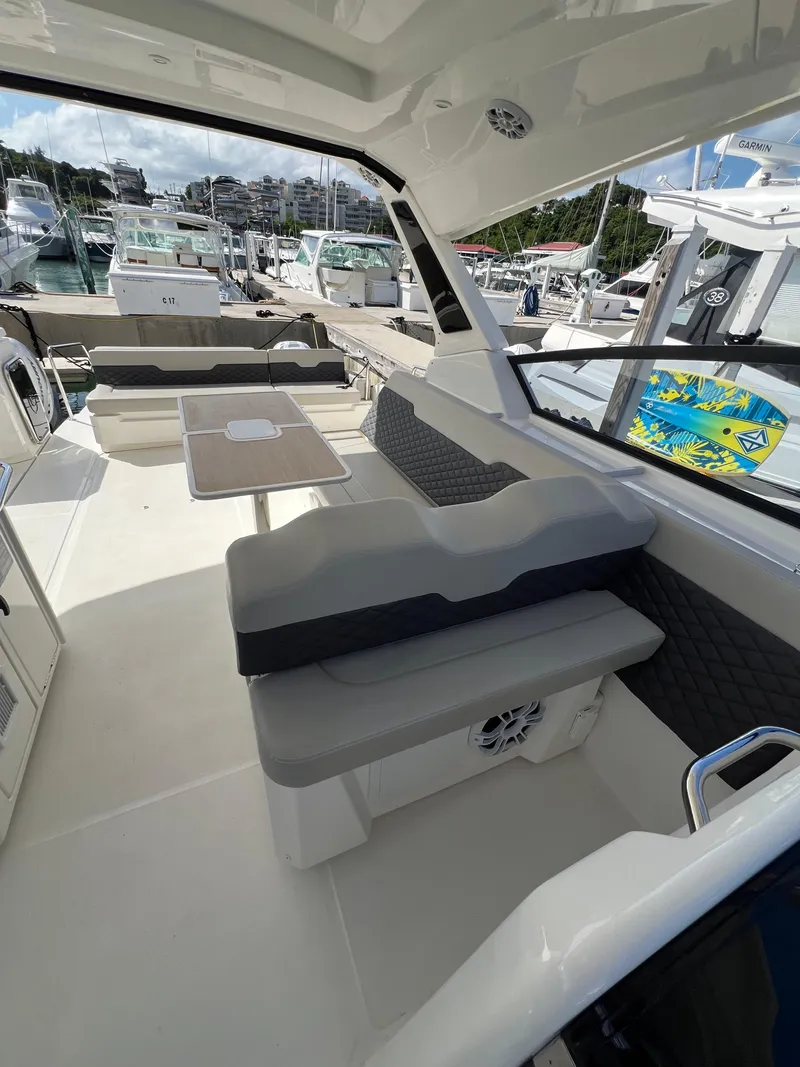 Slide: The Image of 2023 Aquila 36 Sport yacht interior with seating and table, docked at marina. - 37