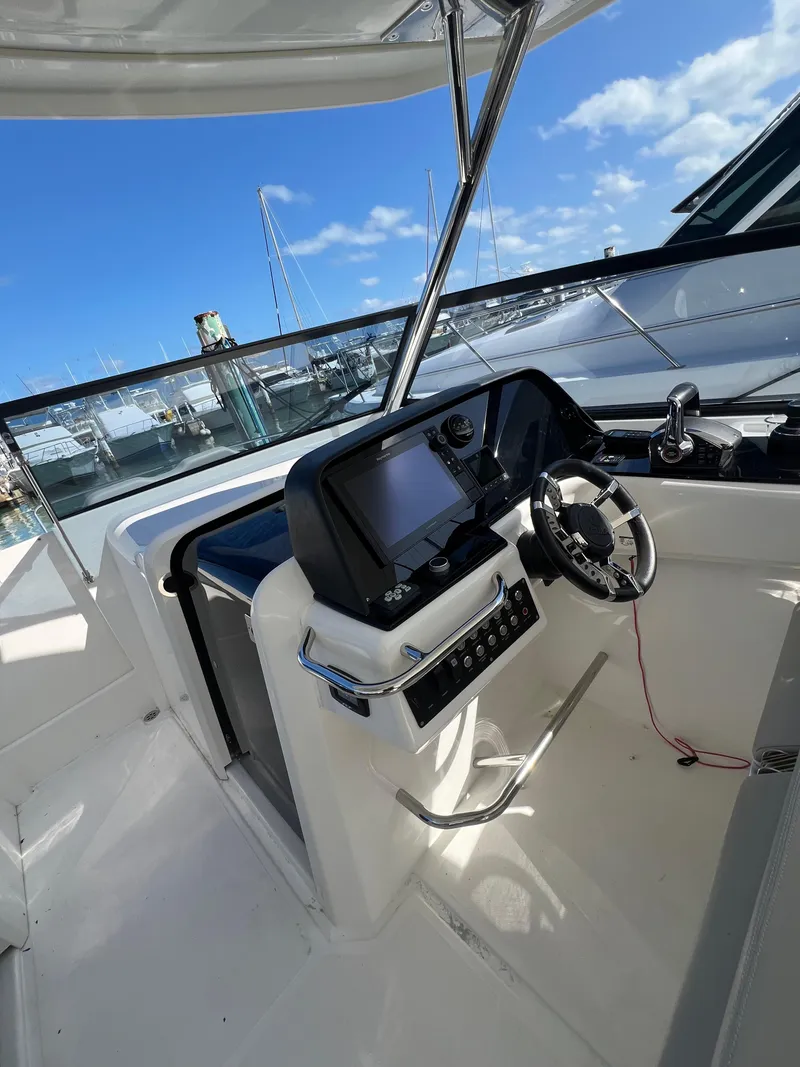 Slide: The Image of 2023 Aquila 36 Sport boat helm with modern controls and steering wheel. - 38