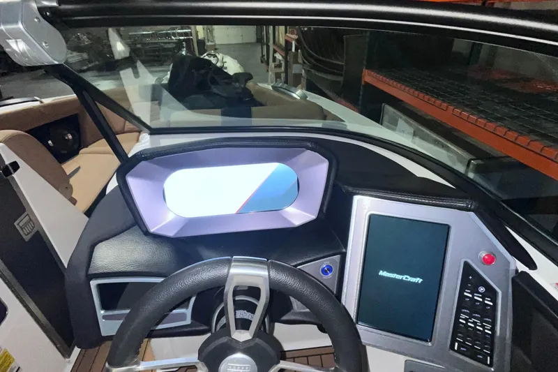 Slide: The Image of 2022 MasterCraft X24 boat dashboard with modern controls and steering wheel. - 12