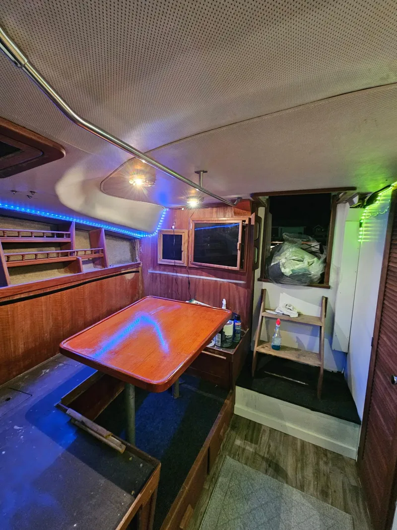Slide: The Image of 1984 Topaz 36 Sportfisherman interior with wooden table, shelves, and ambient lighting. - 11