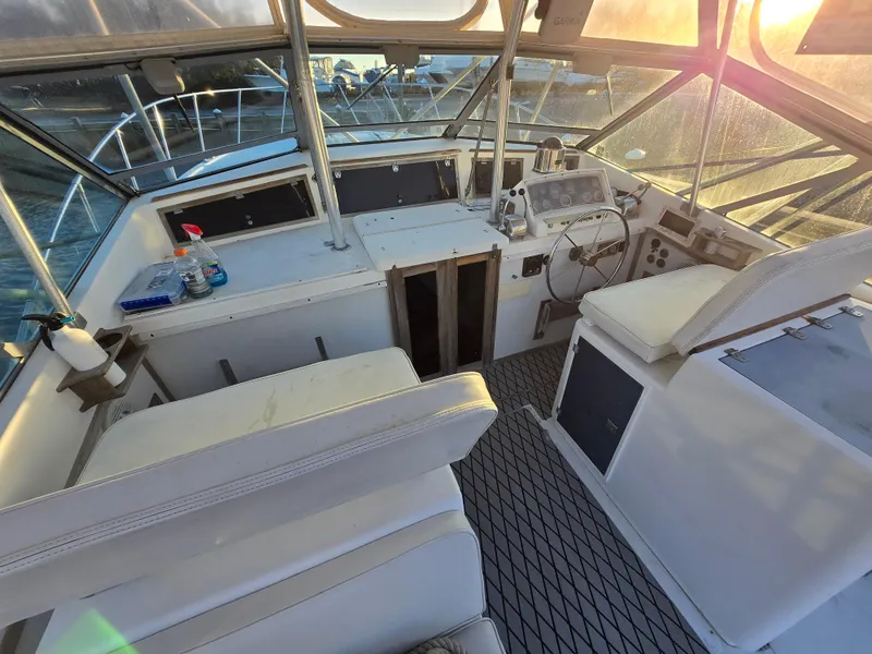 Slide: The Image of 1984 Topaz 36 Sportfisherman boat interior with helm, seating, and sunset view. - 12