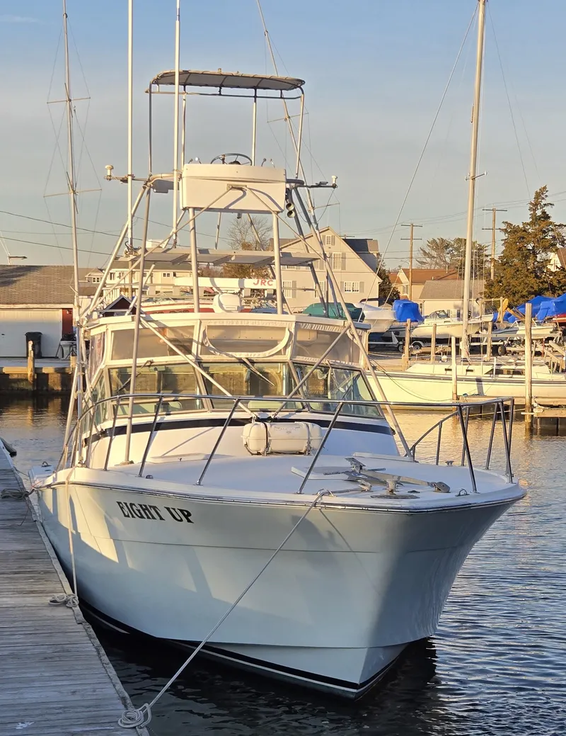 Slide: The Image of 1984 Topaz 36 Sportfisherman boat docked at marina, front view. - 22
