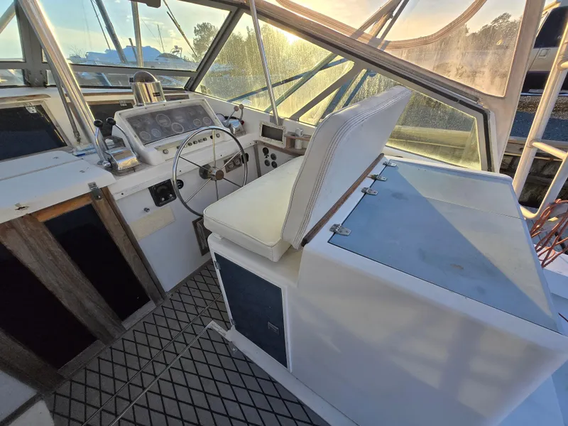 Slide: The Image of 1984 Topaz 36 Sportfisherman boat interior with steering wheel and seating area. - 7
