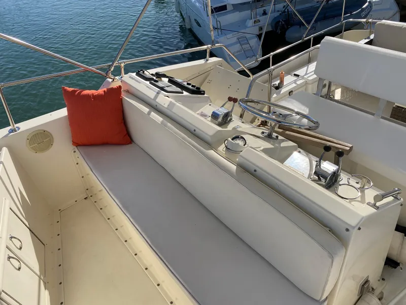 Slide: The Image of 1987 Hatteras Double Cabin boat interior with steering wheel and seating area. - 13