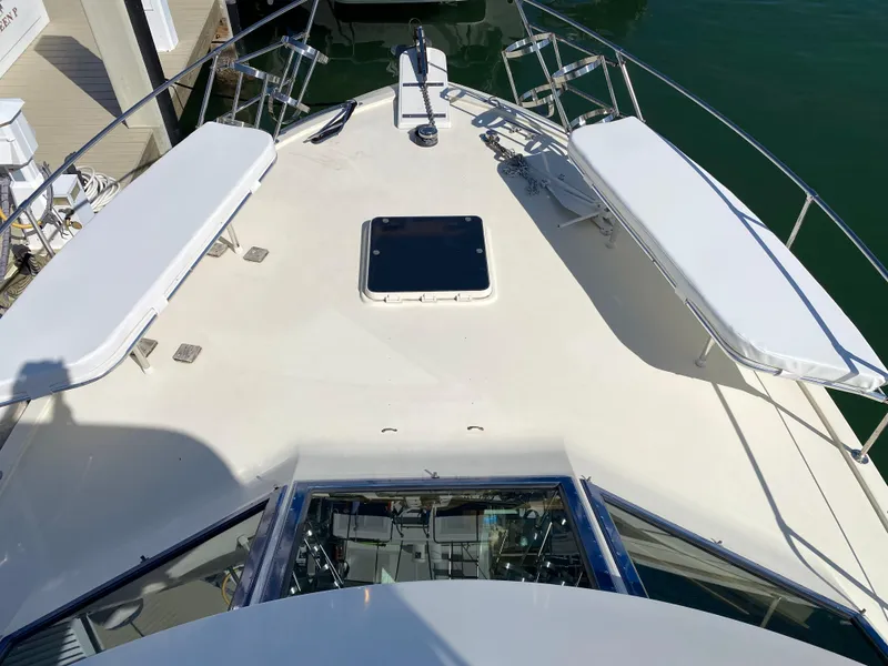 Slide: The Image of 1987 Hatteras Double Cabin yacht deck with seating and hatch, docked in marina. - 14