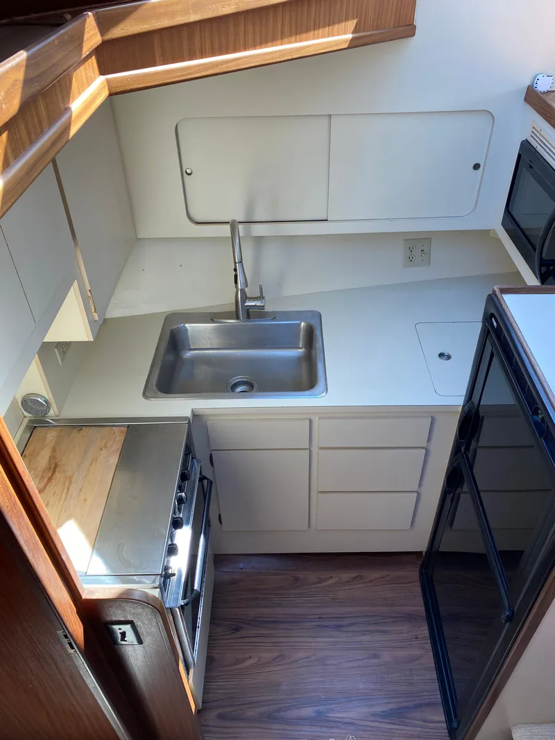 Slide: The Image of 1987 Hatteras Double Cabin kitchen with sink, stove, and cabinetry. - 4