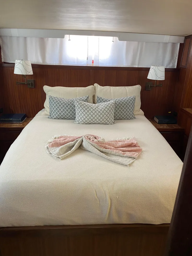 Slide: The Image of Cozy bedroom in 1987 Hatteras Double Cabin yacht with elegant bedding and wooden accents. - 6