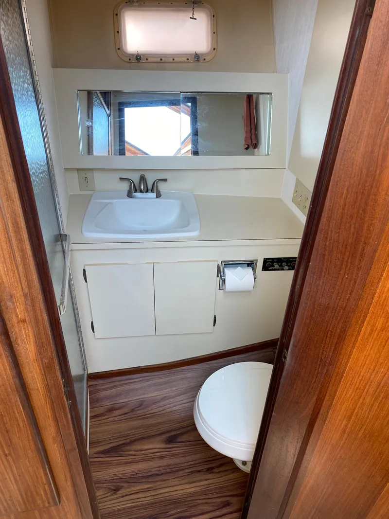 Slide: The Image of 1987 Hatteras Double Cabin bathroom with sink, mirror, and toilet. - 7