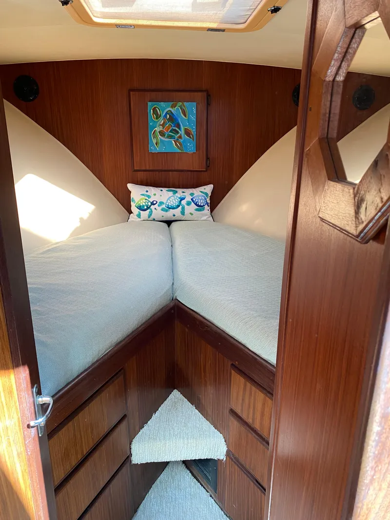 Slide: The Image of 1987 Hatteras Double Cabin interior with cozy V-berth and wooden paneling. - 8
