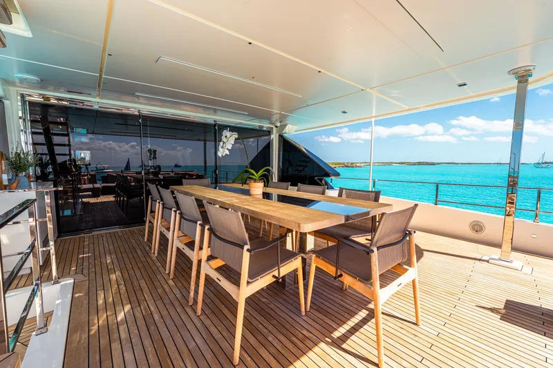 Slide: The Image of Luxurious outdoor dining area on 2018 Custom Line Navetta 33 yacht, overlooking serene ocean views. - 7