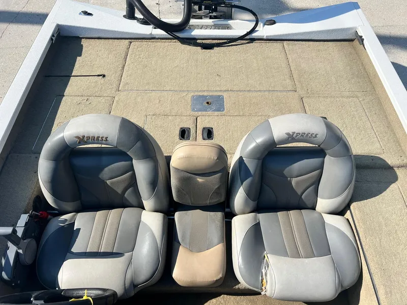 Slide: The Image of 2013 Express H18 boat interior with four cushioned seats and beige flooring. - 6