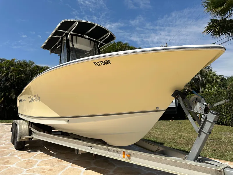 Slide: The Image of 2013 Sea Hunt Ultra 225 boat on trailer, parked outdoors under clear sky. - 0