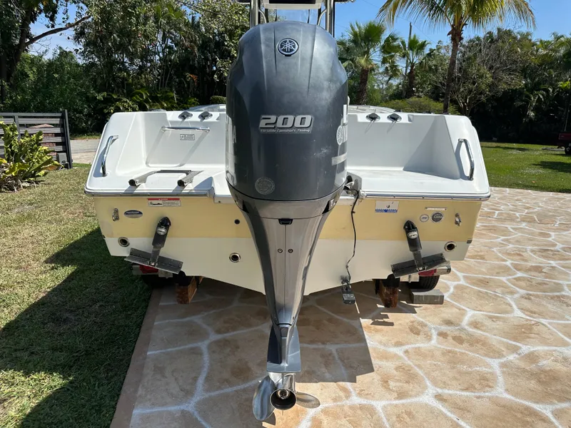 Slide: The Image of 2013 Sea Hunt Ultra 225 boat with Yamaha 200 engine, parked on stone driveway. - 10