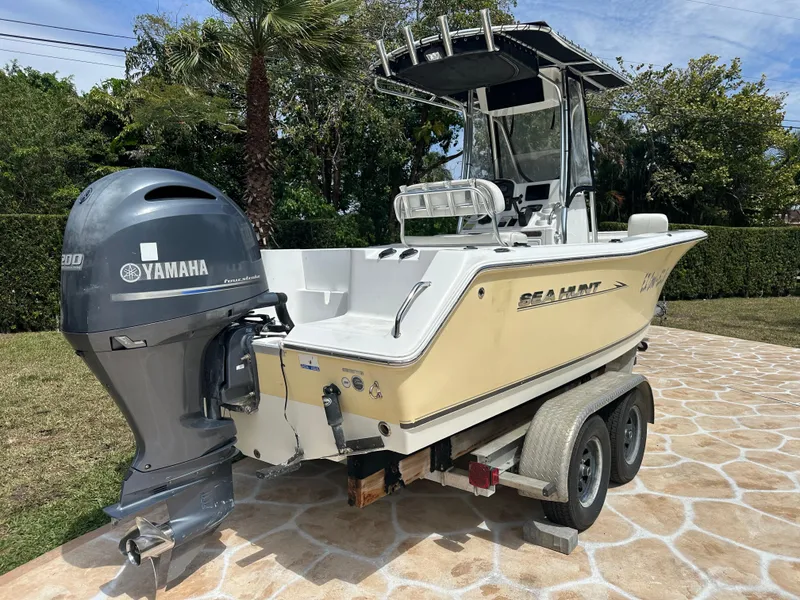 Slide: The Image of 2013 Sea Hunt Ultra 225 boat with Yamaha engine on a trailer, parked outdoors. - 11