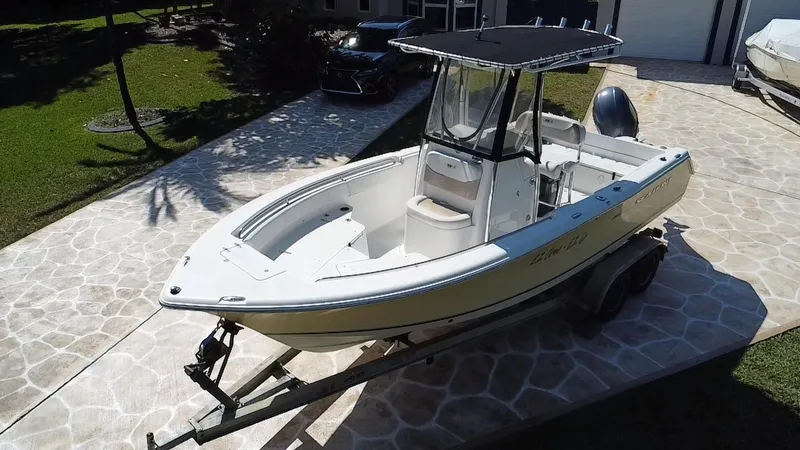 Slide: The Image of 2013 Sea Hunt Ultra 225 boat on trailer, parked on stone driveway. - 17