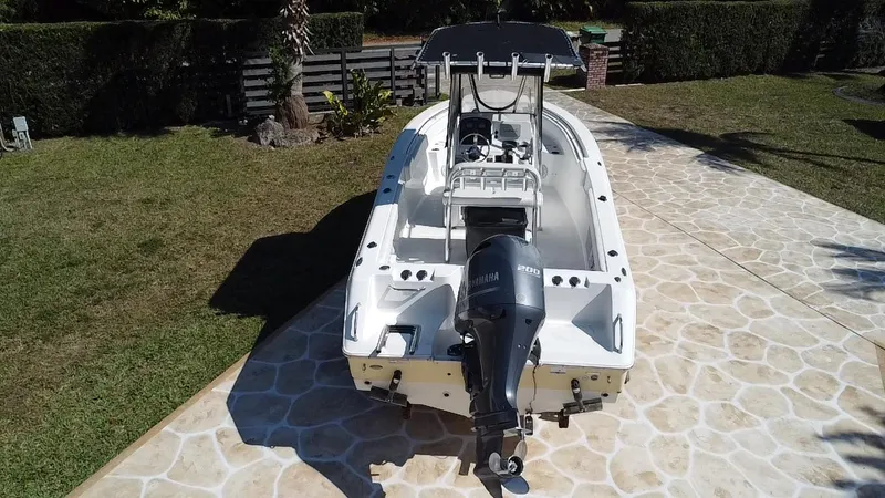 Slide: The Image of 2013 Sea Hunt Ultra 225 boat with Yamaha outboard motor on a stone driveway. - 20