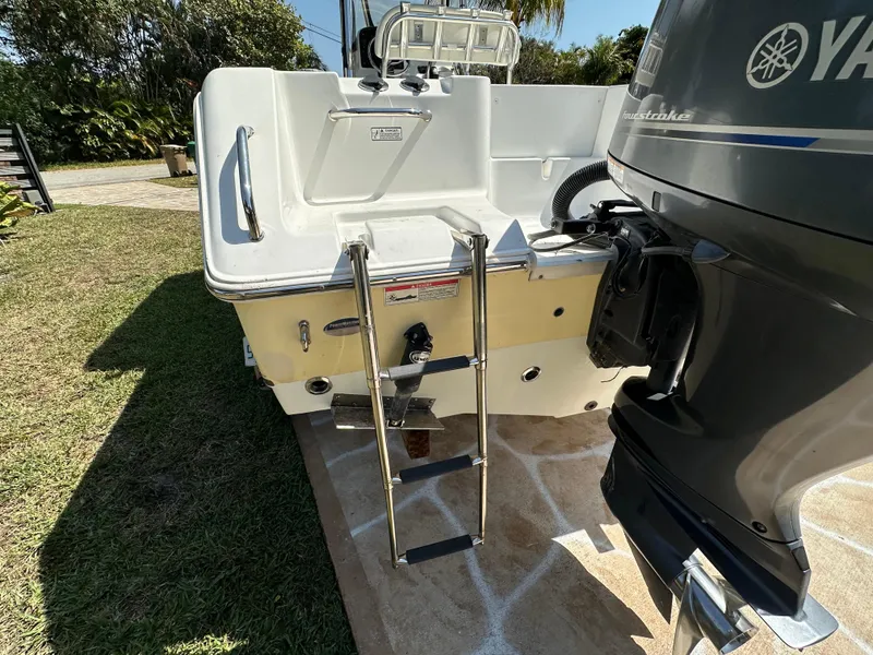 Slide: The Image of 2013 Sea Hunt Ultra 225 boat with Yamaha engine and swim ladder on a sunny day. - 22