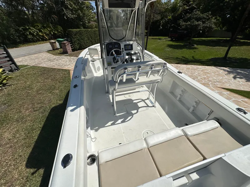 Slide: The Image of 2013 Sea Hunt Ultra 225 boat interior with console and seating, parked on grass. - 23
