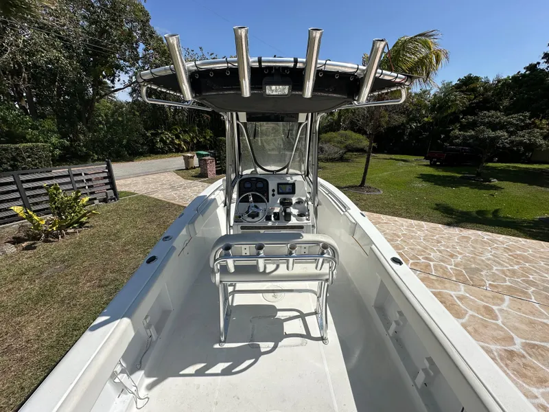 Slide: The Image of 2013 Sea Hunt Ultra 225 boat interior with console and seating, parked outdoors. - 24