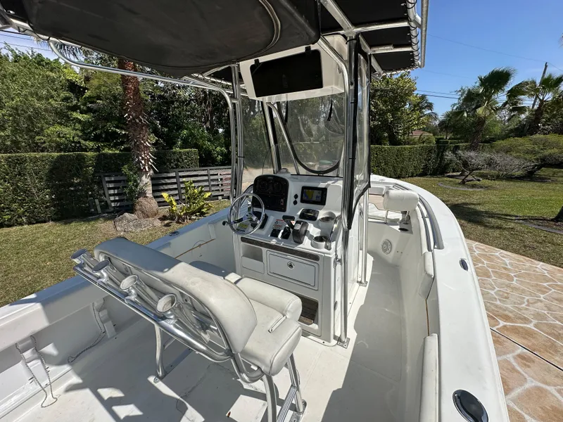 Slide: The Image of 2013 Sea Hunt Ultra 225 boat with console and seating, parked outdoors. - 25