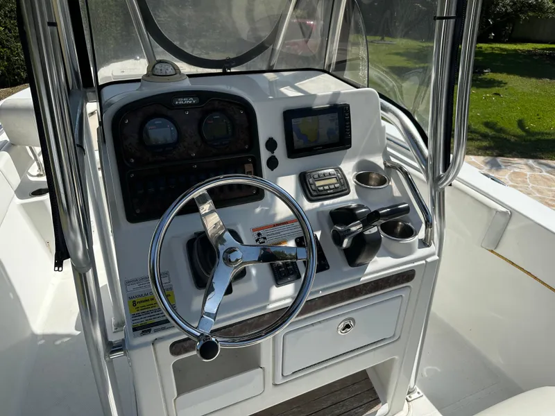 Slide: The Image of 2013 Sea Hunt Ultra 225 boat console with steering wheel, gauges, and navigation system. - 26