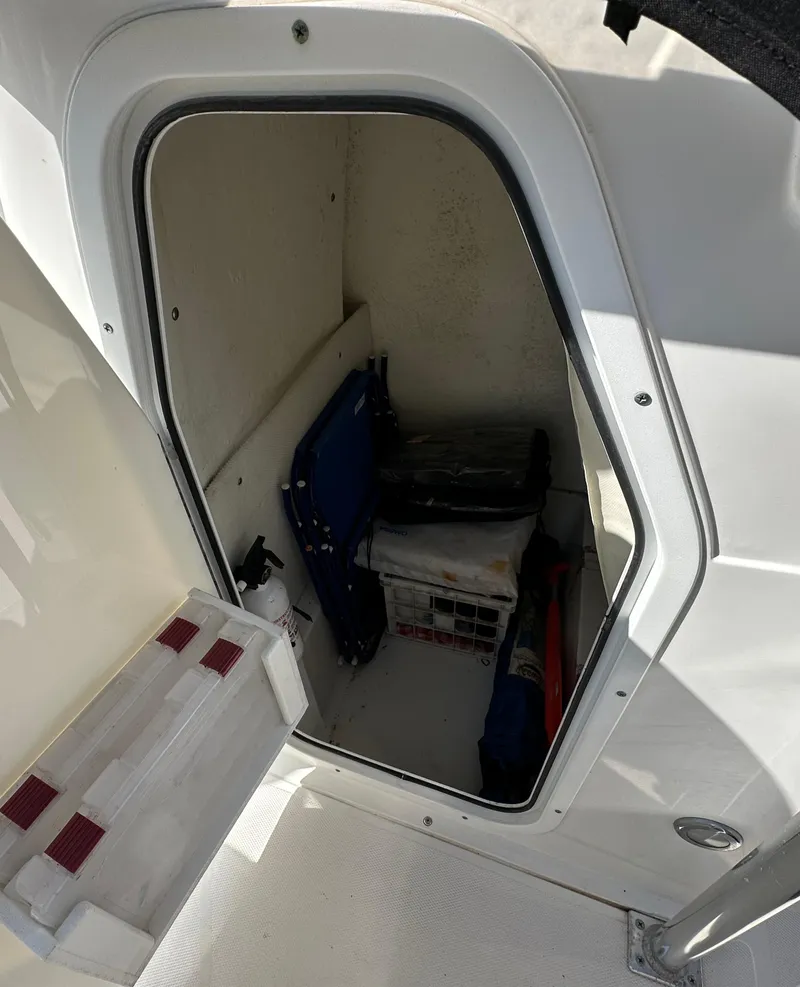 Slide: The Image of Storage compartment inside a 2013 Sea Hunt Ultra 225 boat, featuring various equipment. - 32