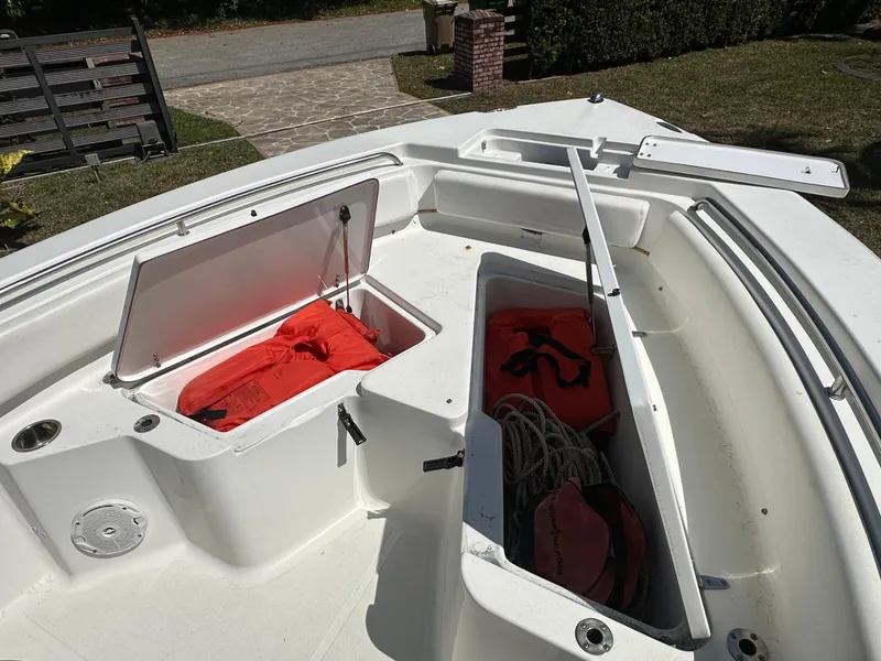 Slide: The Image of 2013 Sea Hunt Ultra 225 boat with open storage compartments and safety gear. - 38