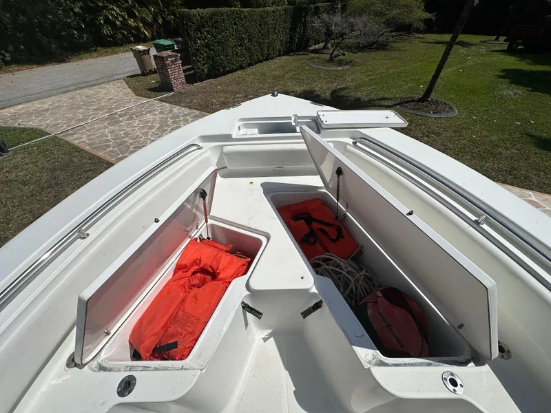 Slide: The Image of 2013 Sea Hunt Ultra 225 boat with open storage compartments and safety gear. - 39