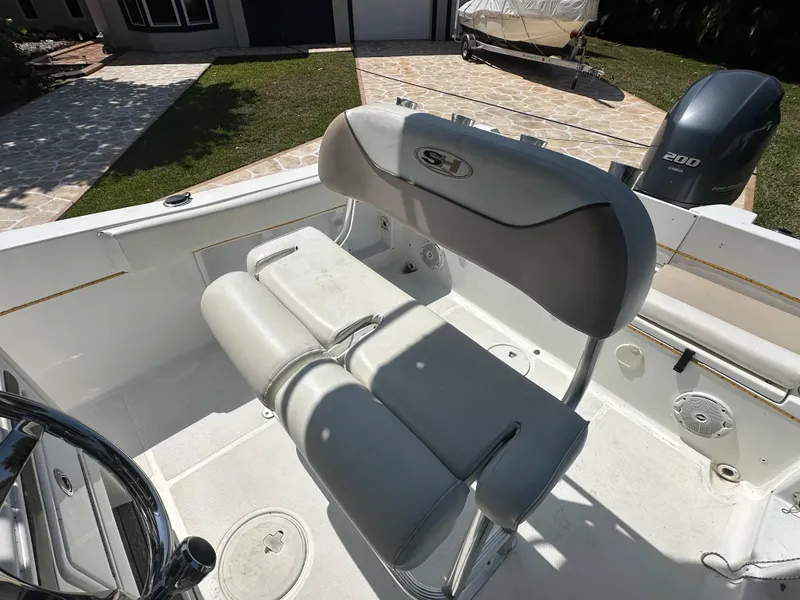 Slide: The Image of 2013 Sea Hunt Ultra 225 boat interior with cushioned seating and Yamaha engine. - 49