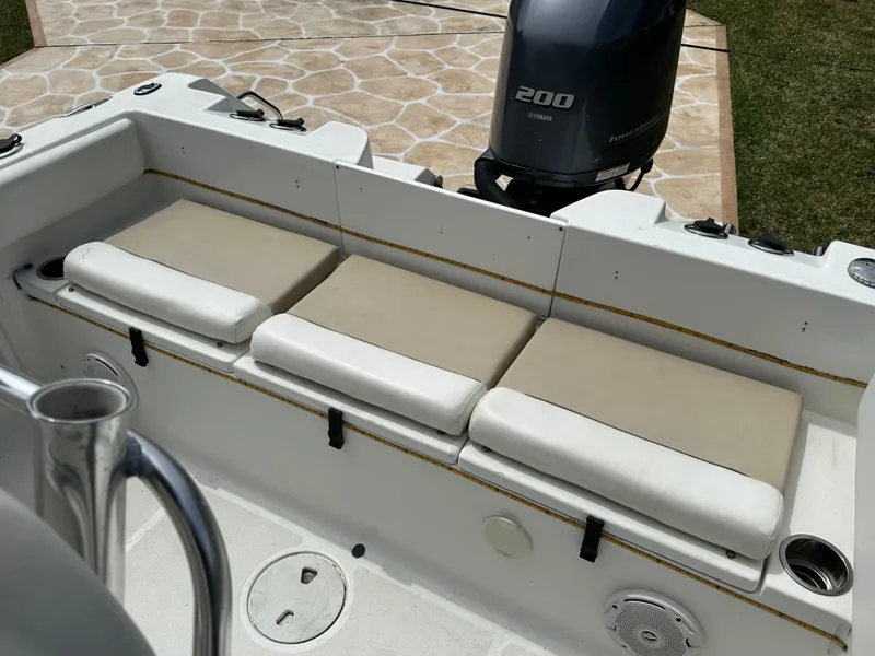 Slide: The Image of 2013 Sea Hunt Ultra 225 boat interior with cushioned seating and Yamaha 200 engine. - 51