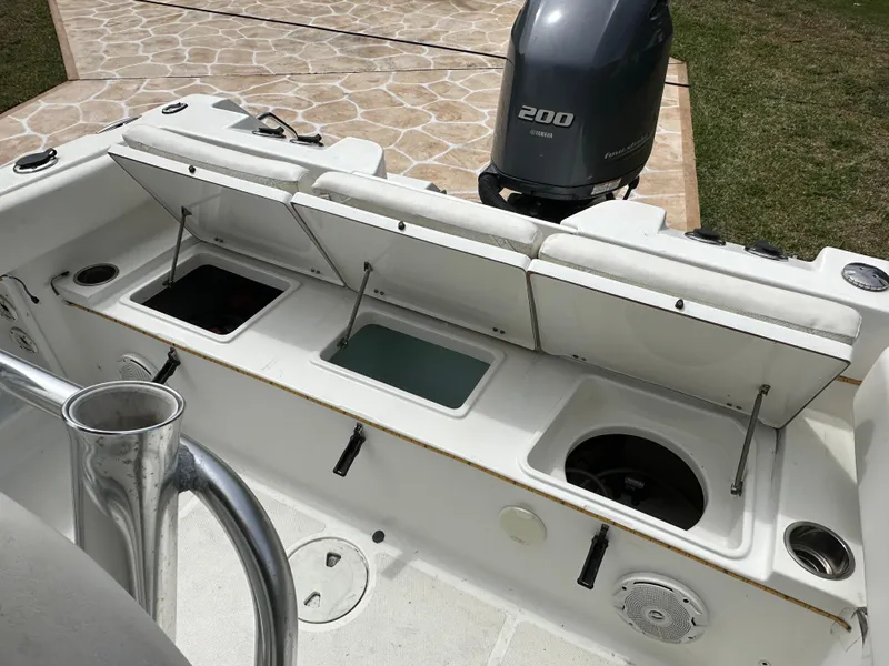 Slide: The Image of 2013 Sea Hunt Ultra 225 boat with open storage compartments and a 200 HP engine. - 53