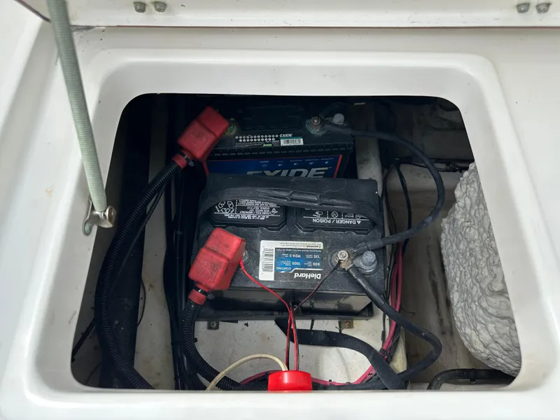 Slide: The Image of Battery compartment of a 2013 Sea Hunt Ultra 225 boat, featuring Exide marine batteries. - 54