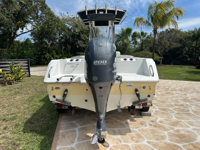 Slide: The Image of 2013 Sea Hunt Ultra 225 boat with Yamaha 200 engine, parked on stone driveway. - 58