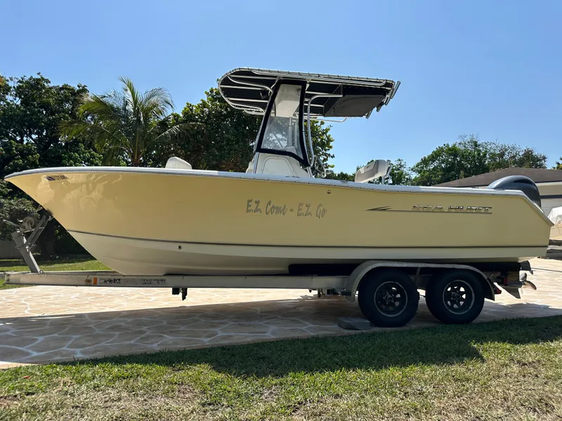 Slide: The Image of 2013 Sea Hunt Ultra 225 boat on trailer, parked outdoors on a sunny day. - 7