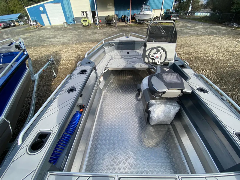 Slide: The Image of 2025 Stabicraft 1550 Frontier Adventure boat interior with steering console, docked outdoors. - 2