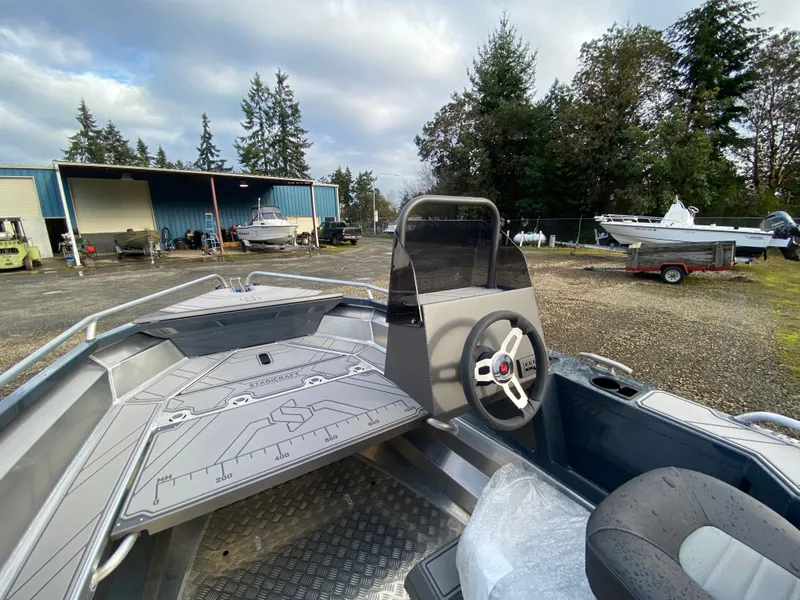 Slide: The Image of 2025 Stabicraft 1550 Frontier Adventure boat with steering console, parked outdoors. - 3