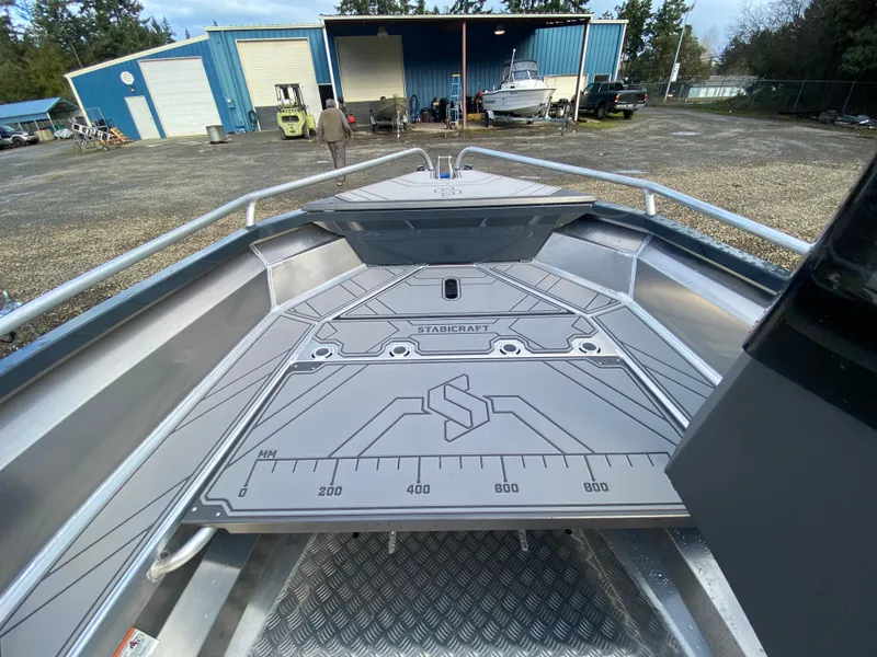 Slide: The Image of 2025 Stabicraft 1550 Frontier Adventure boat deck at a marina with blue buildings. - 5