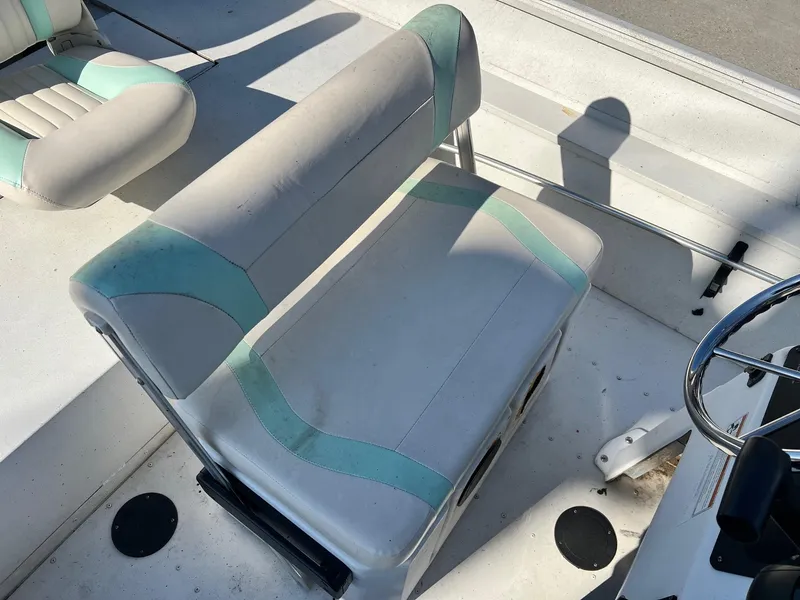 Slide: The Image of 2019 G3 Bay 20 boat seat with teal accents and steering wheel. - 7