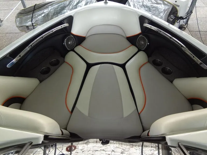 Slide: The Image of 2010 Malibu VLX WAKESETTER boat interior with cushioned seating and cup holders. - 10