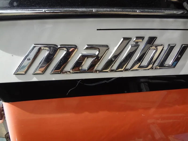 Slide: The Image of 2010 Malibu VLX WAKESETTER logo on orange and white boat exterior. - 30