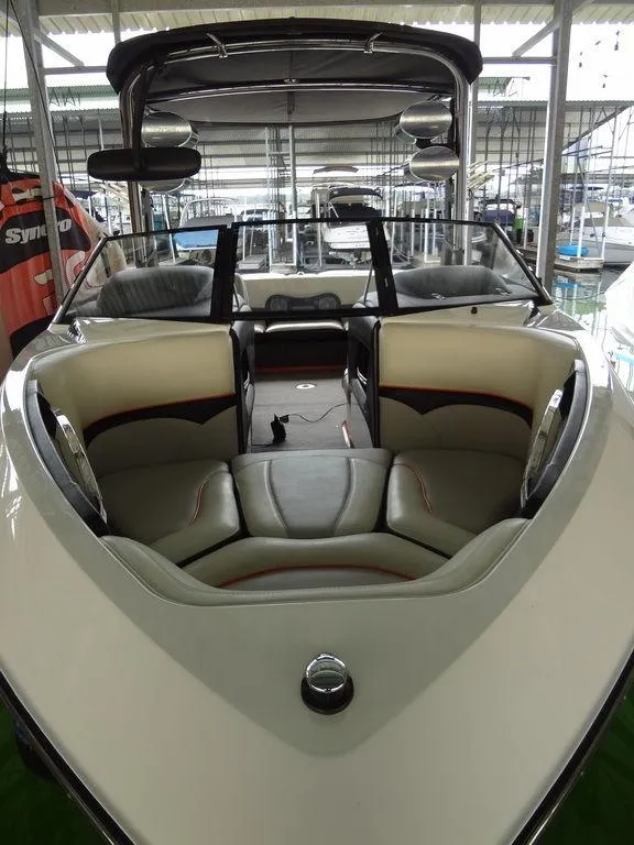 Slide: The Image of 2010 Malibu VLX Wakesetter boat interior with sleek seating in a marina. - 5